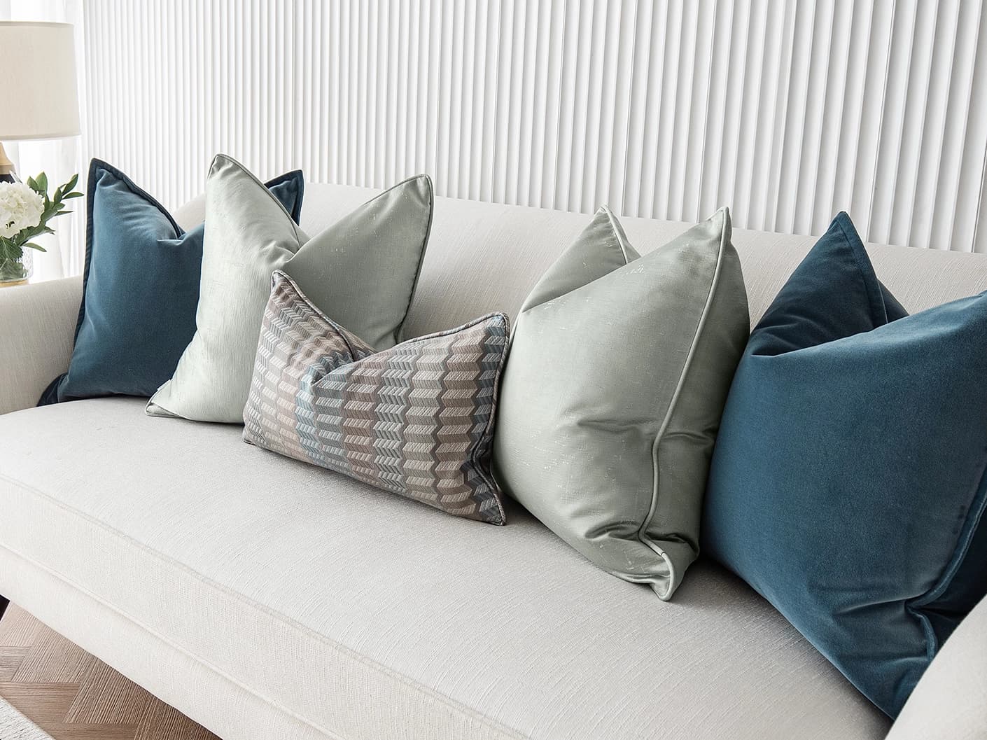 Dionisia Bundle bundle cushions in silver, blue and green, shown in a lifestyle front view