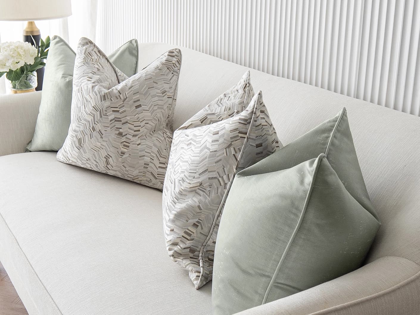 Marjorie Bundle bundle cushions in silver, grey and green, shown in a lifestyle front view