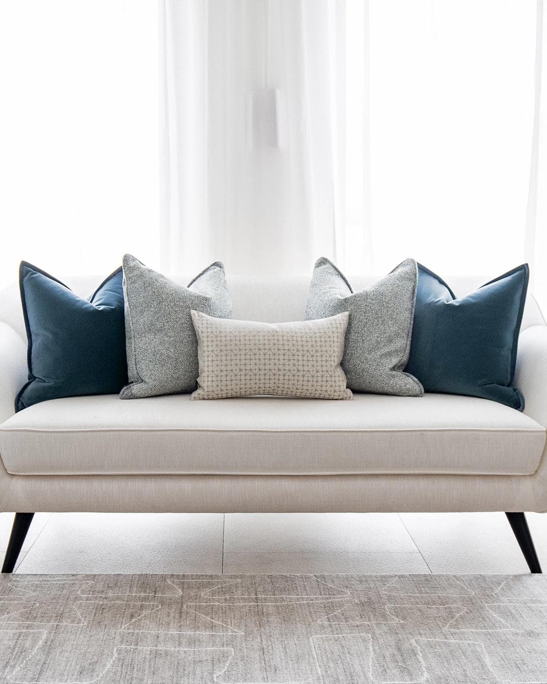 Samuel Bundle cushion in blue, silver and white, shown in a lifestyle front view as image 4
