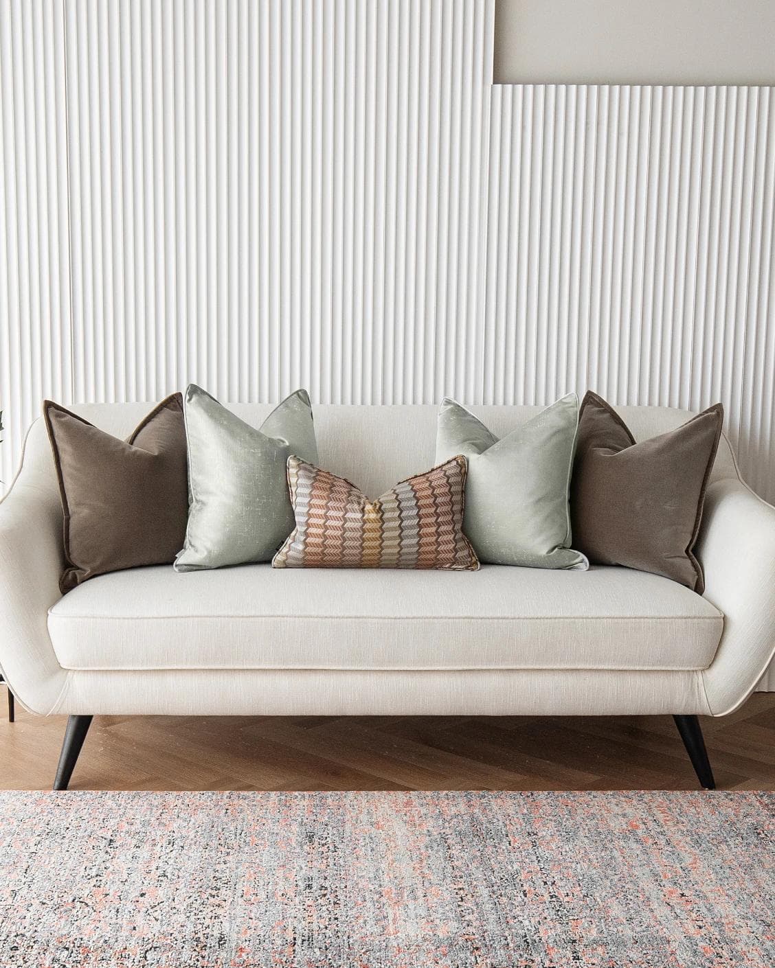 Eliazar Bundle cushion in brown, orange, silver and green, shown in a lifestyle front view as image 4