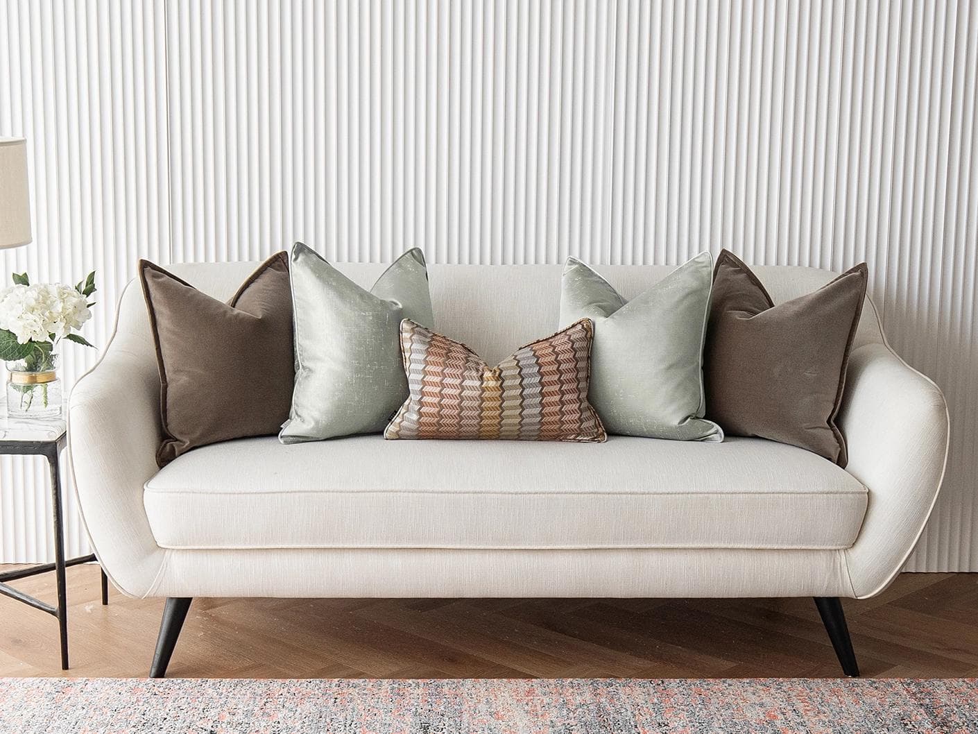 Eliazar Bundle cushion in brown, orange, silver and green, shown in a lifestyle front view as image 4
