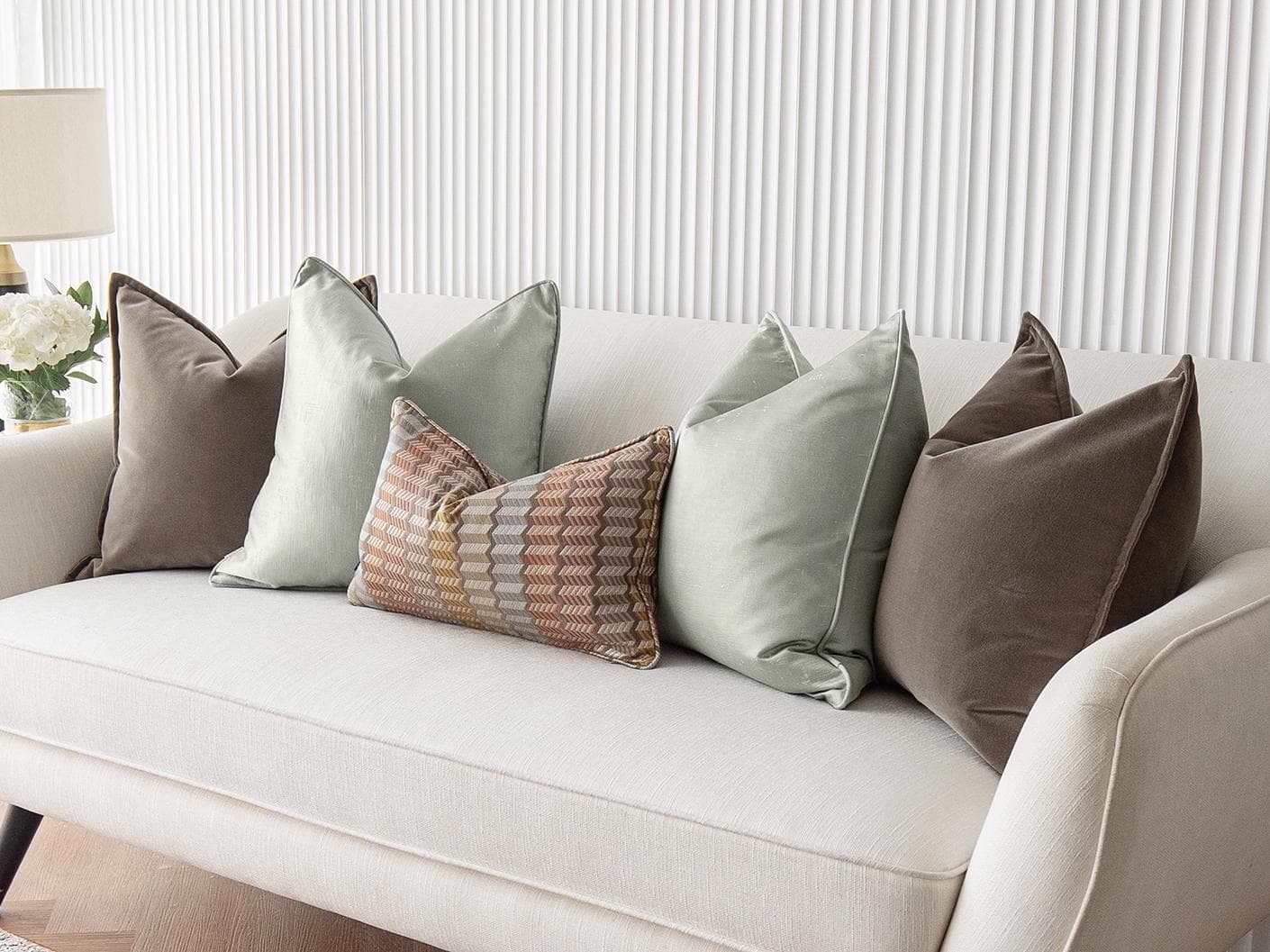 Eliazar Bundle cushion in brown, orange, silver and green, shown in a lifestyle right view as image 2