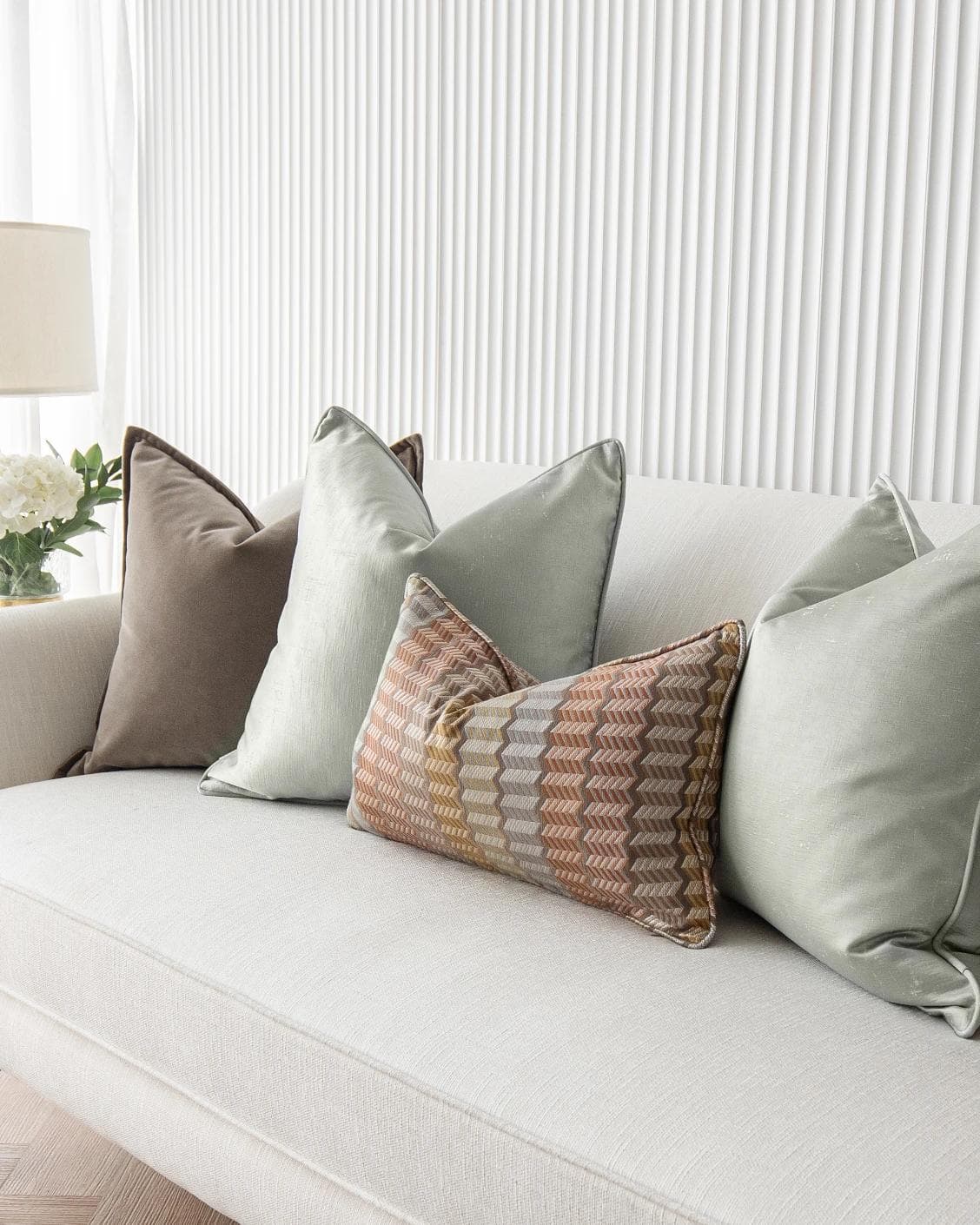 Eliazar Bundle cushion in brown, orange, silver and green, shown in a lifestyle right view as image 5