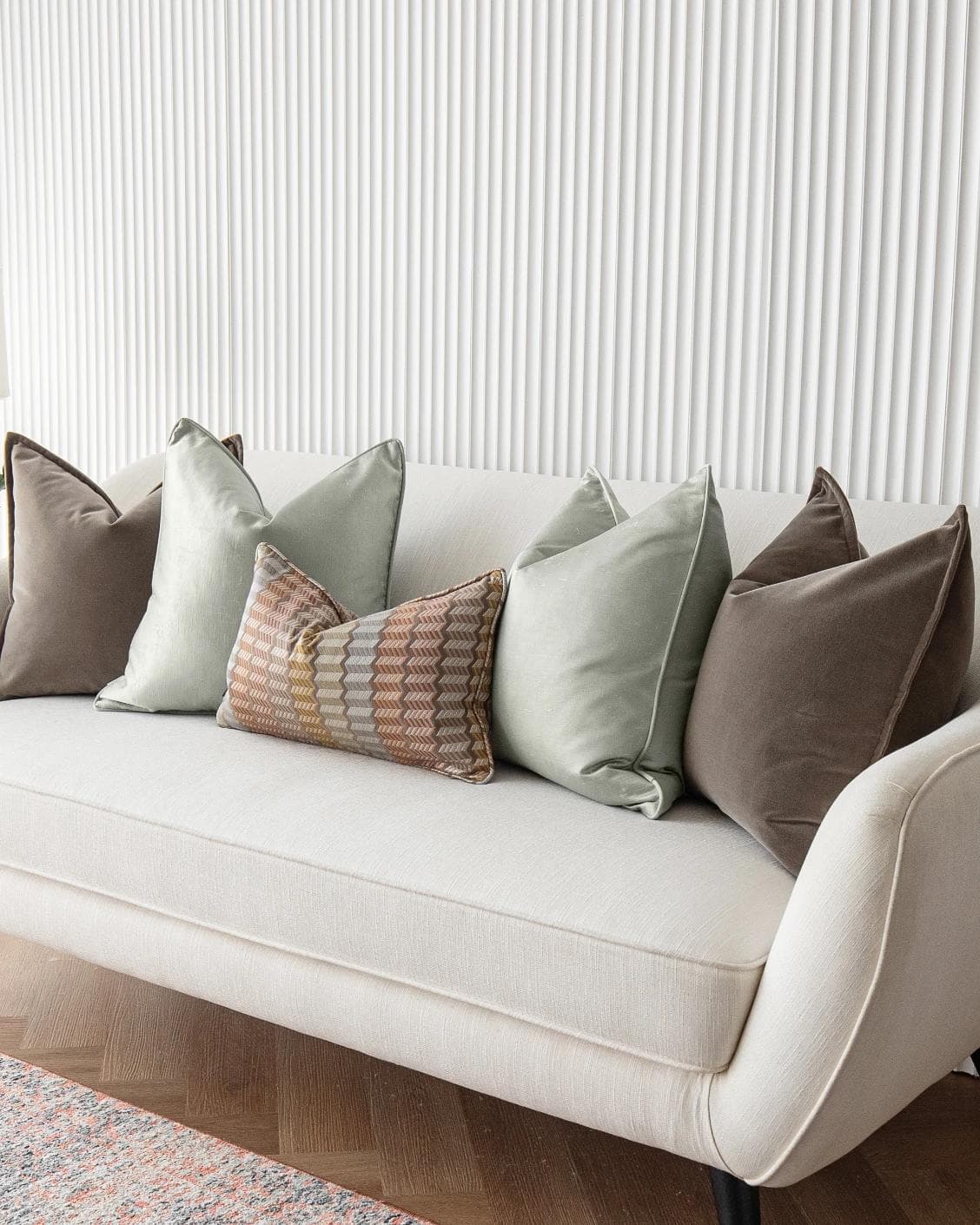 Eliazar Bundle cushion in brown, orange, silver and green, shown in a lifestyle right view as image 2