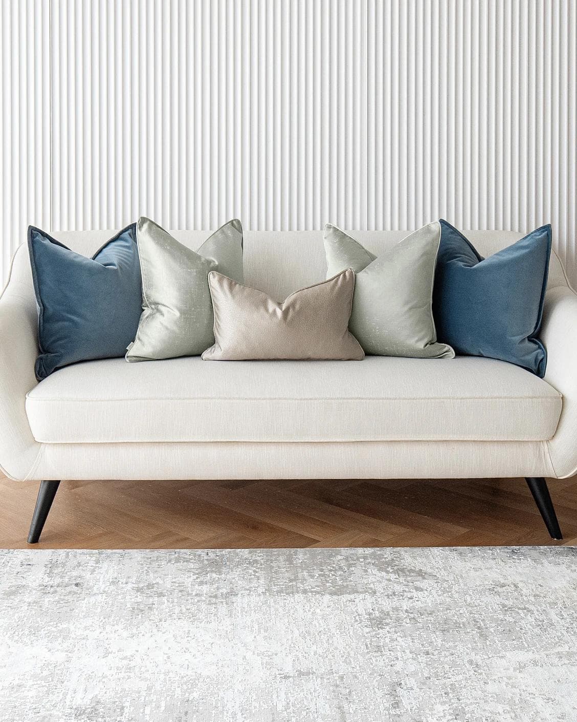 Johnston Bundle cushion in gold, blue, beige, green and silver, shown in a lifestyle front view as image 2