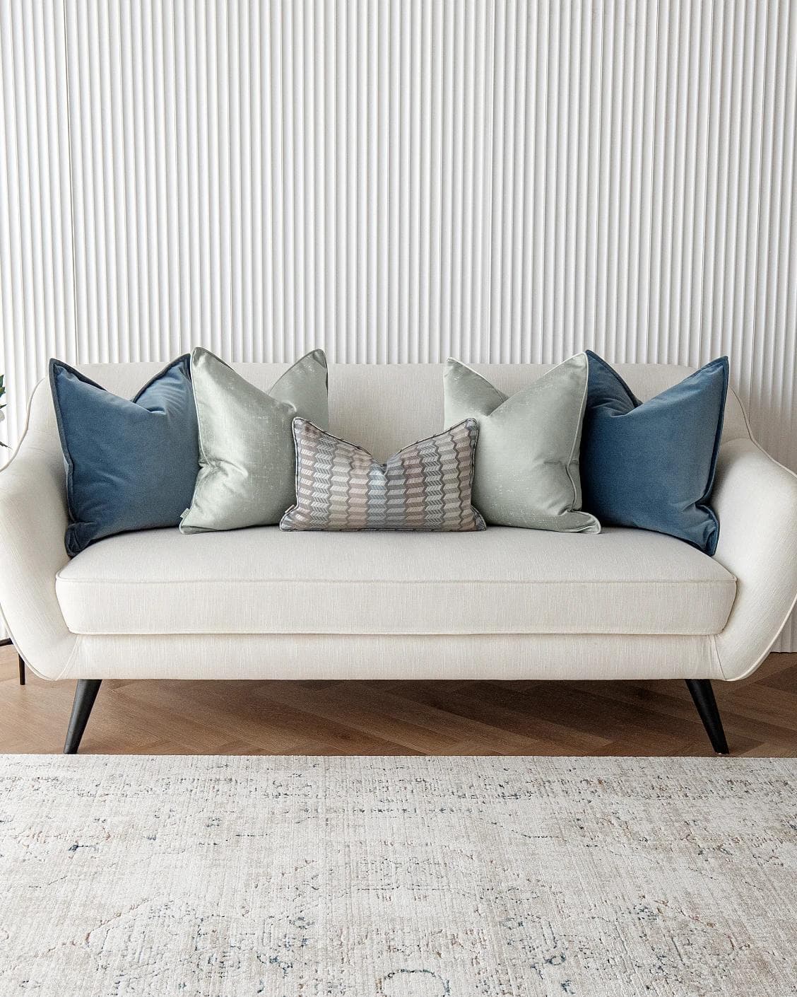 Dionisia Bundle cushion in silver, blue and green, shown in a lifestyle front view as image 4